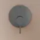 Brausearmatur in Magnetic Grey von Ideal Standard, mit einem runden Bedienfeld und einem langen Hebel, montiert an einer hellen Wand.